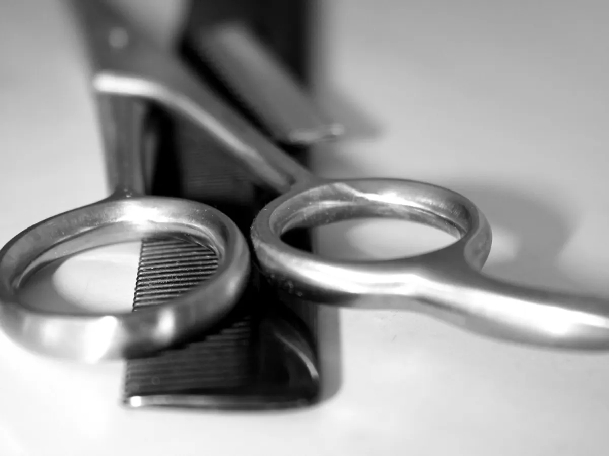 Gunting dan sisir tertata di atas meja kerja kapster